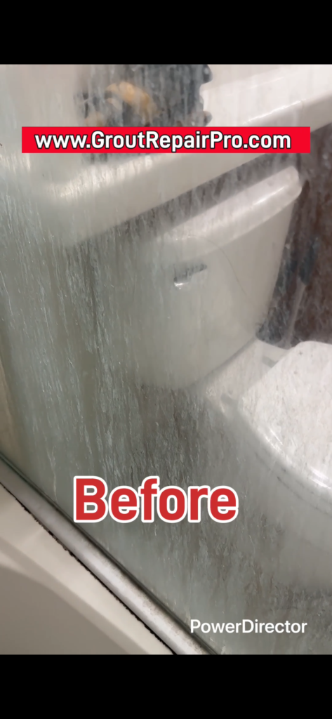 Heavy hard water and soap scum buildup on shower glass enclosure.