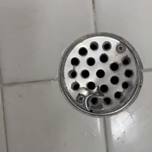 Excavated primary shower drain assembly cleared of scale