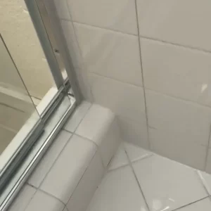 Finished shower floor with white epoxy grout and silicone transitions
