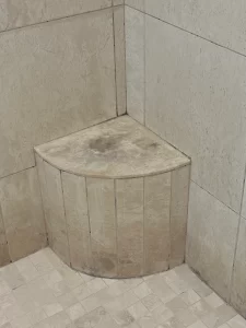 Detailed close up of restored natural stone tile grout joints and silicone perimeter seals